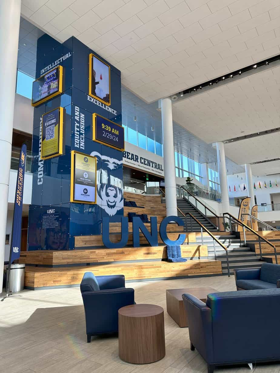 A rendering of the University of Northern Colorado lobby with blue couches and chairs.